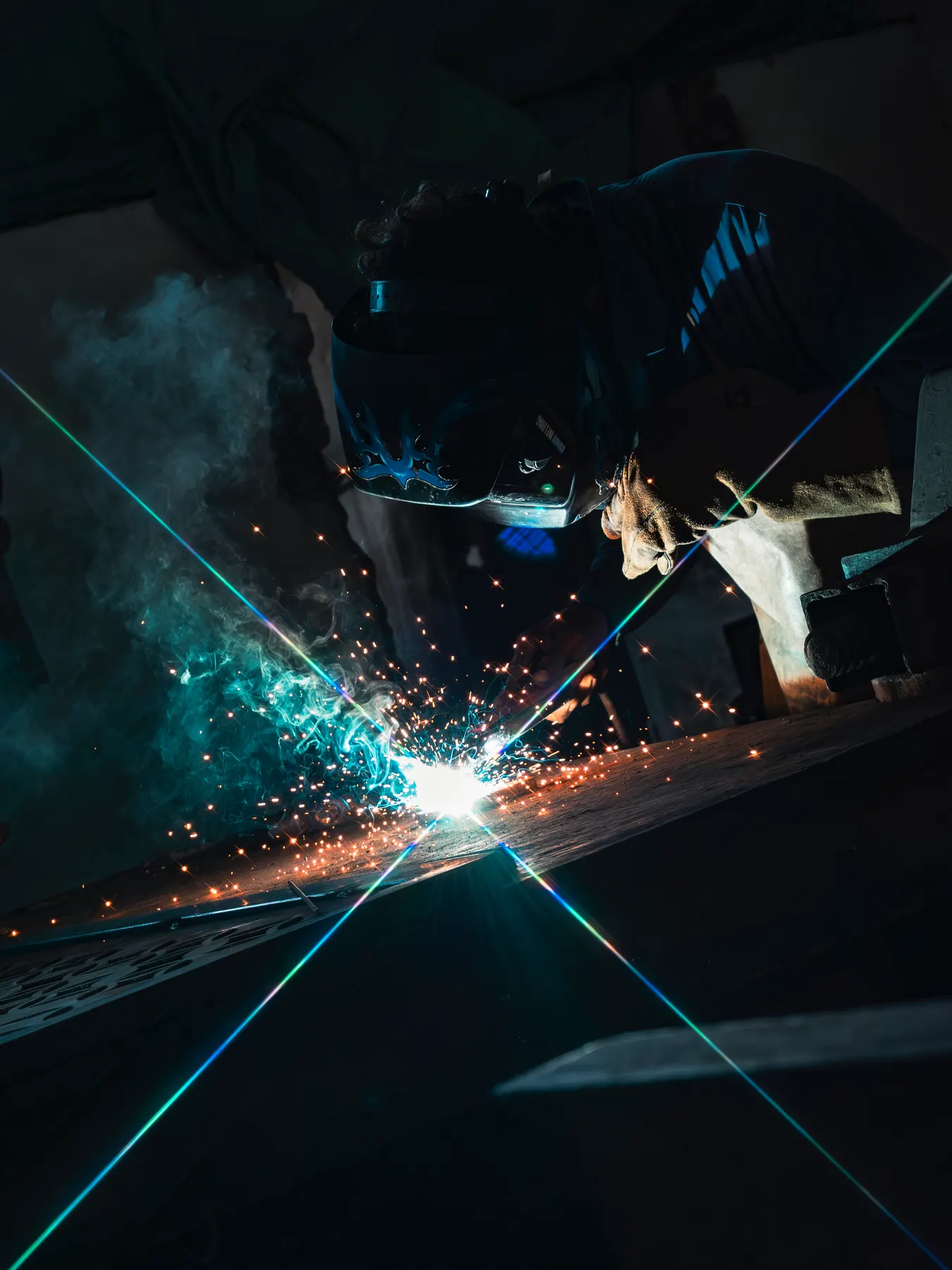Soldador trabajando, con chispas en primer plano