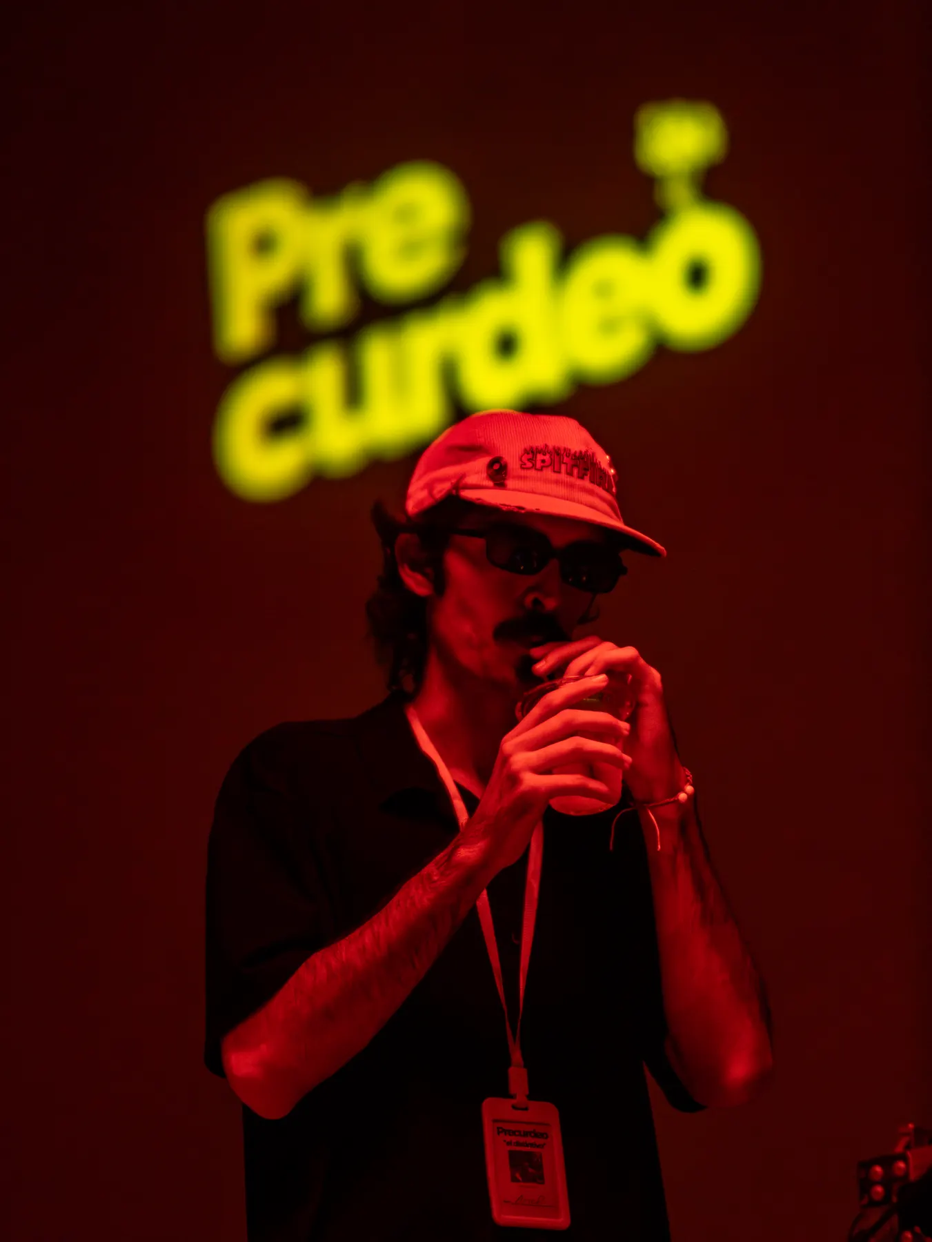 Chico bajo el letrero de neón de Precurdeo