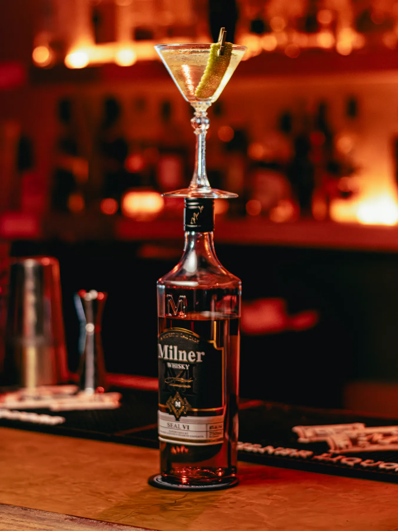 Botella de Milner y un martini sobre la barra