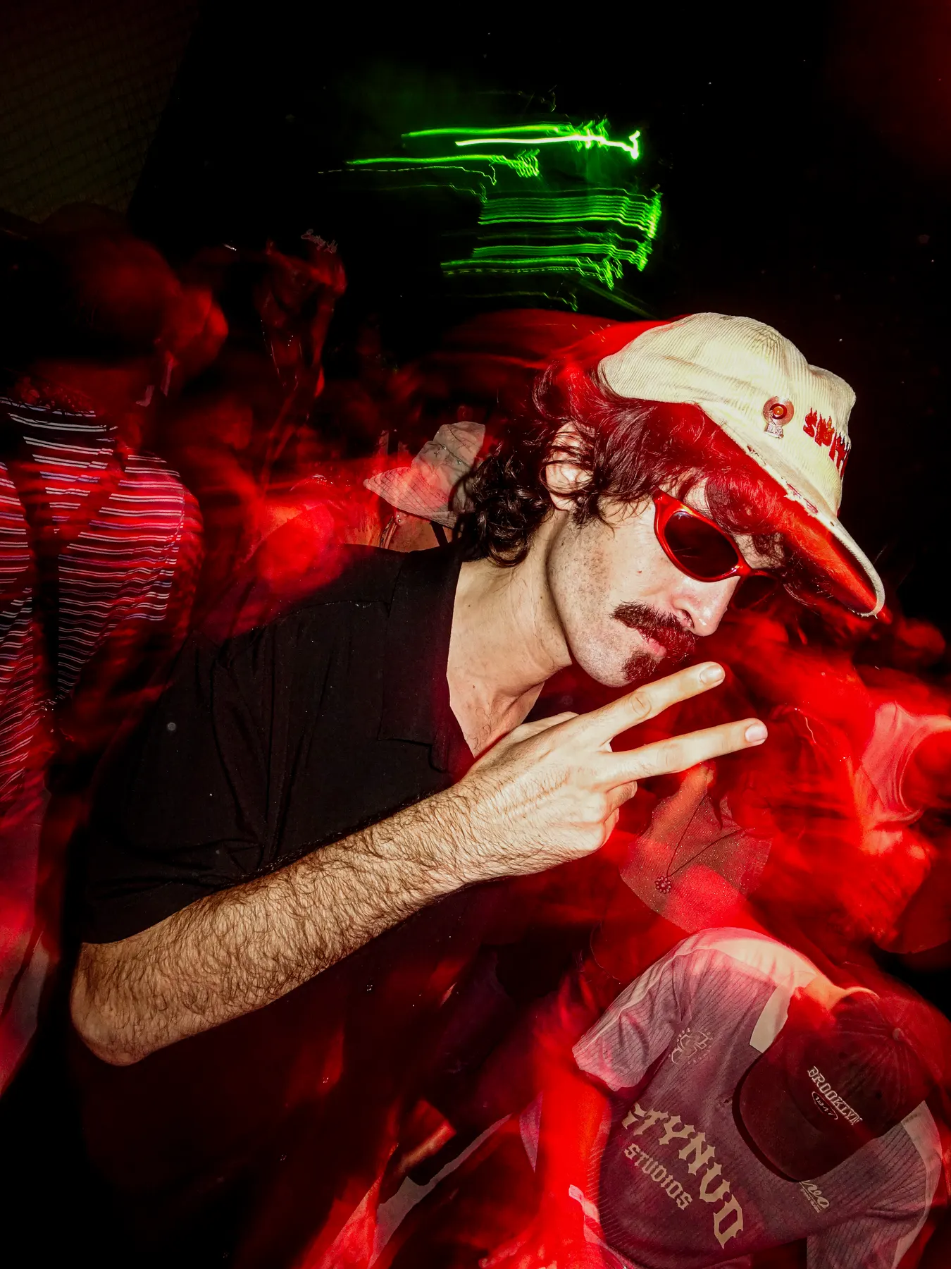 Chico con gorra haciendo el signo de la paz con flash
