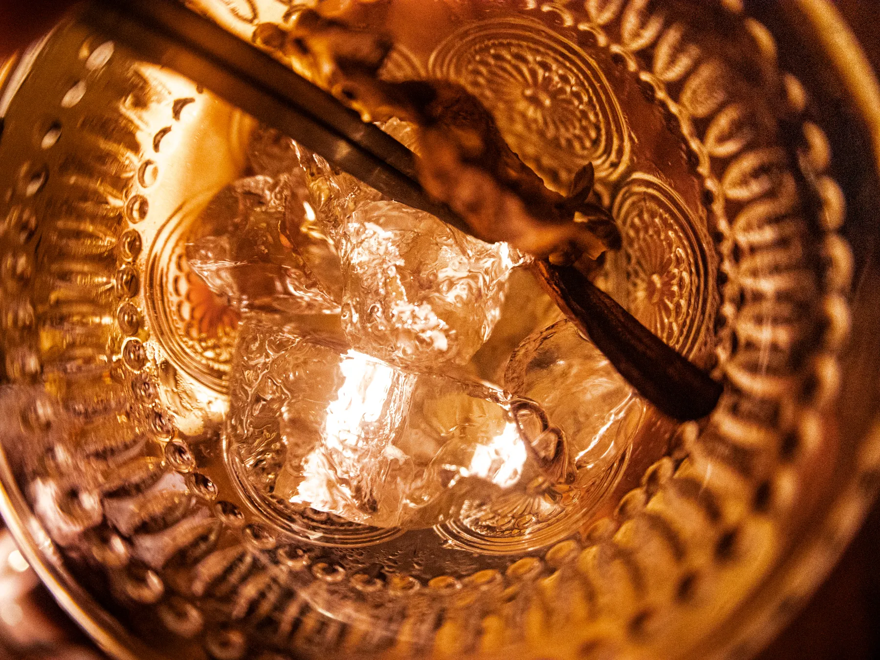 Hielo y pinzas en un vaso tallado, en primer plano