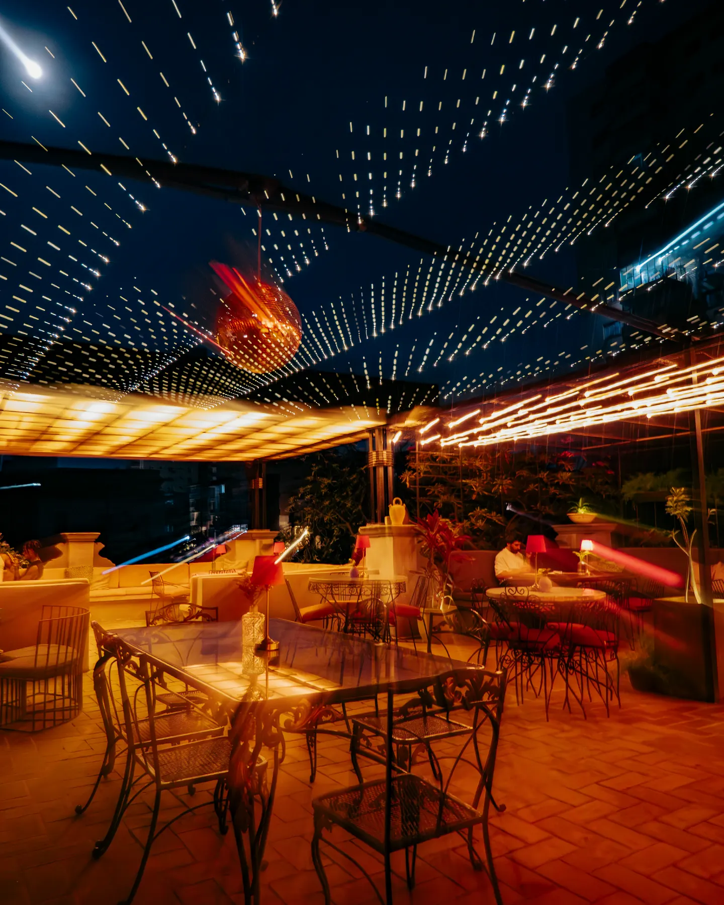 La terraza de Trama de noche, con luces colgadas