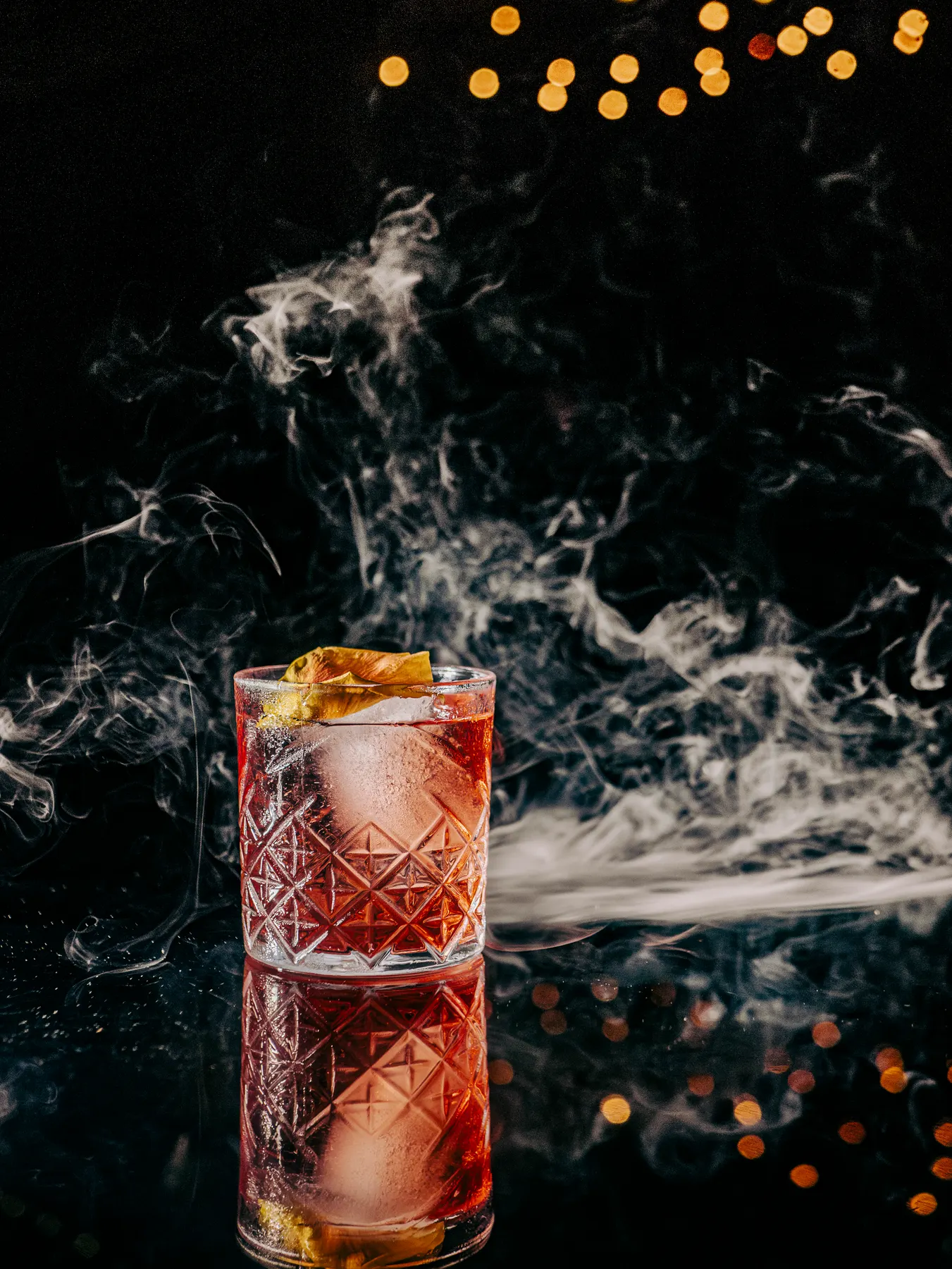 Trago rojo en vaso tallado envuelto en humo