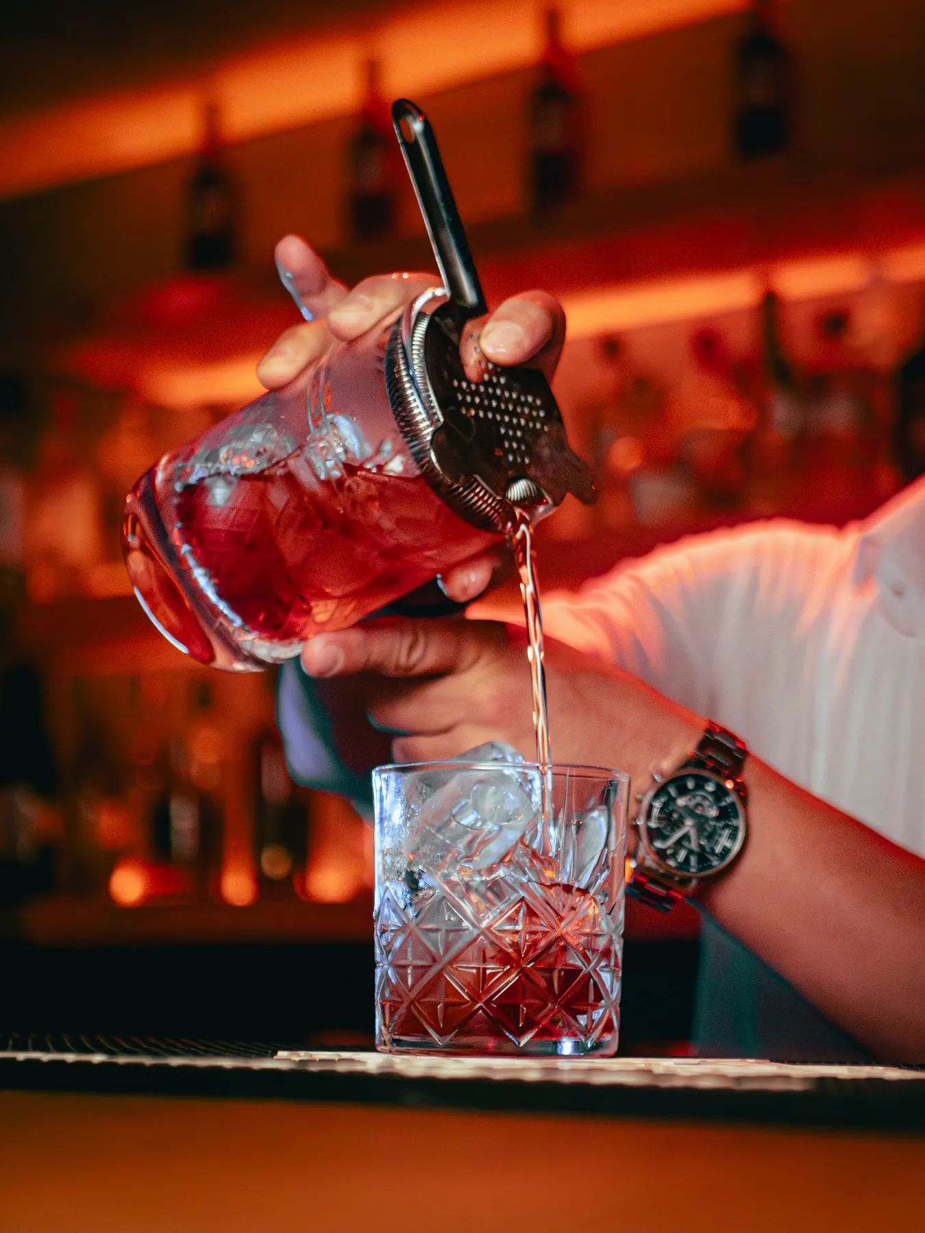 Bartender sirviendo desde la coctelera
